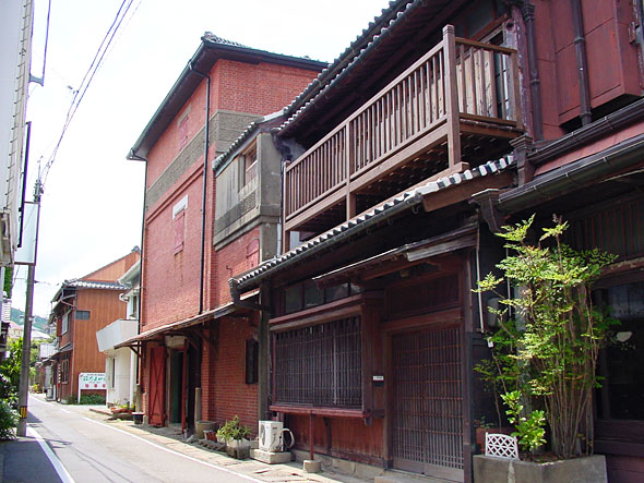 主屋の隣に並んで建つ、赤い煉瓦積みで造られた3階建ての倉庫の写真