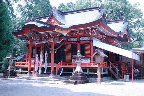 全体的に朱色の外観で、複雑に入り組んだ屋根が特徴的な榎原神社本殿を写した写真