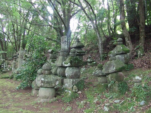 奥に林が生い茂る道の一角に、板碑などが集められている大迫寺跡石塔群の写真