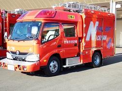 後部に大文字で「FIRE DEPT NICHINAN」と書かれた、赤色のボディのポンプ車を右斜め前から撮影した写真