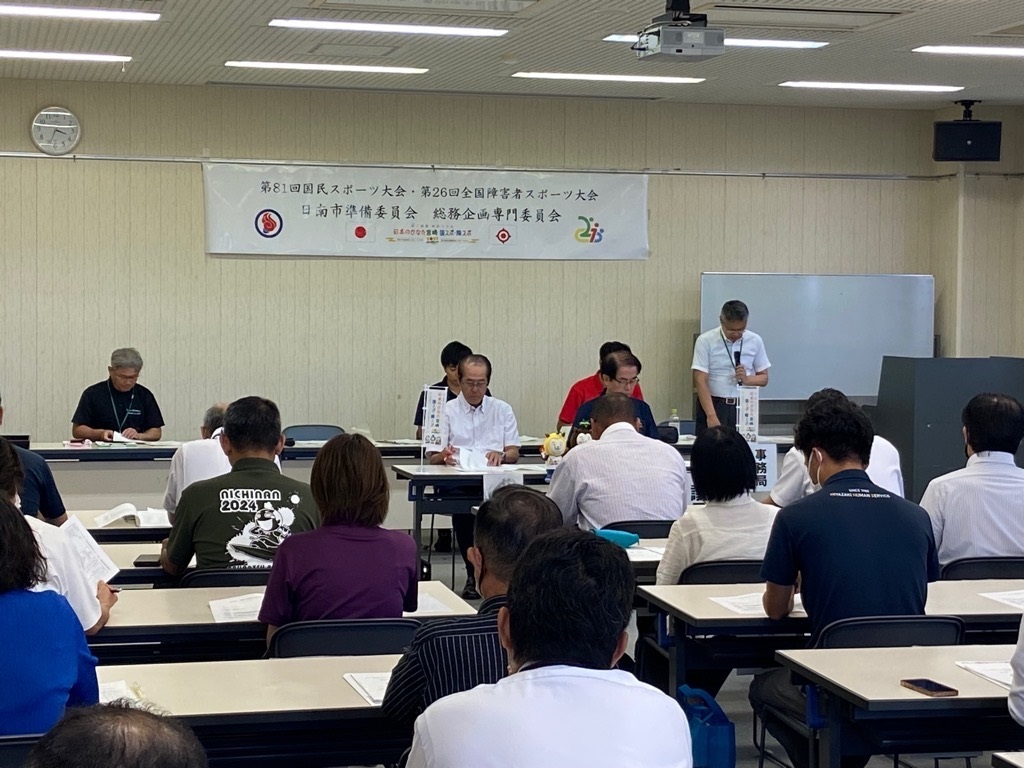 会議で事務局次長が話しているところ