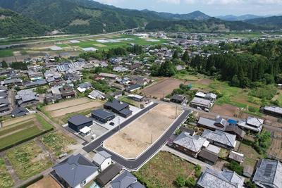 住宅街や林がある土地の一角が更地になっている様子を写した「さくらヒルズ北郷」の写真