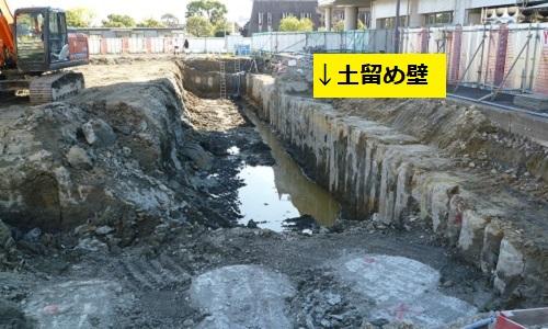 地面に溝が彫られ、溝の横に土留め壁が構築されている写真