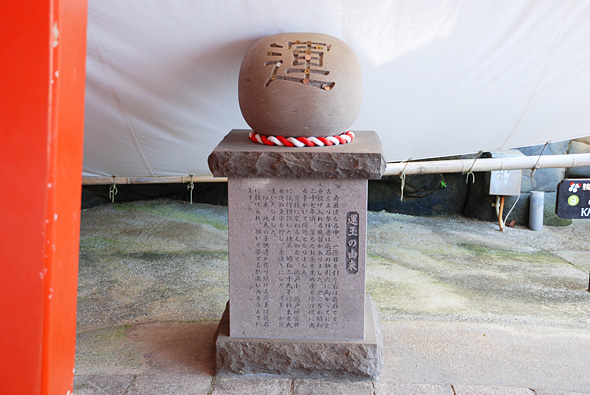 石の台の上に置かれた運と字が刻んである丸い石の写真