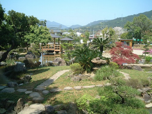 飛び石と岩が配された庭と池が続く日本庭園の写真