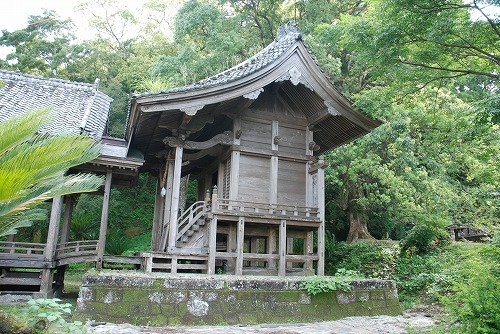 古い建物の渡り廊下から一段床の高い建物へ階段でつながっている様子の写真