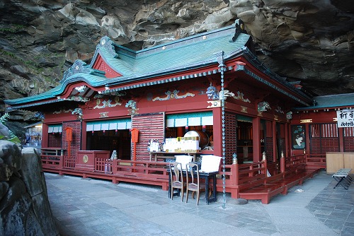 洞窟の中にある朱色の壁の建物の写真
