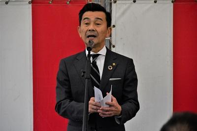 紅白幕の前で挨拶を述べている高橋市長の写真